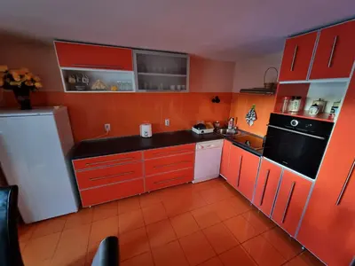 a kitchen with red cabinets and a black appliance at Large, Spacious Apartment Voždovac in Belgrade