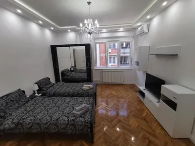 a living room with a bed and a mirror at Victory apartment - Heart of Belgrade in Belgrade