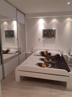 a white bedroom with a bed and a mirror at Viktoria in Belgrade