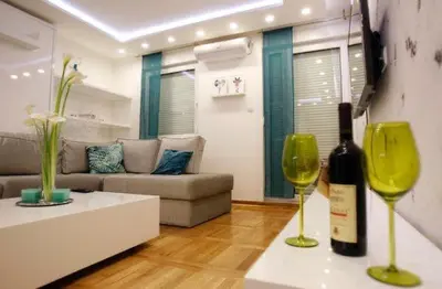 a living room with a bottle of wine and two wine glasses at Babilon in Vračar (historical)