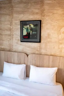 a bed with two pillows and a picture on the wall at Villa ARS in Belgrade