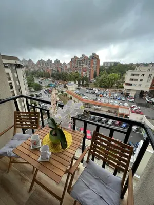 a balcony with a table with a view of a city at Paunov Breg in Jajinci