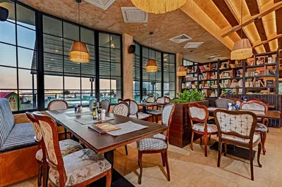 a restaurant with a table and chairs and windows at Hotel Ub Aqua Park in Ub