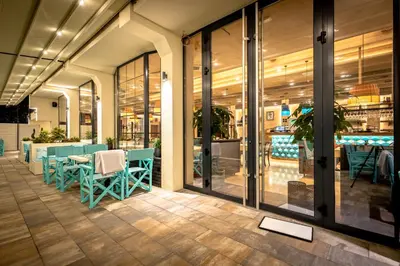 a restaurant with blue chairs and tables in a building at Hotel Ub Aqua Park in Ub