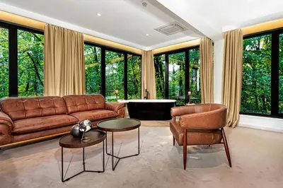 a living room with a couch and chairs and windows at Hotel Ub Aqua Park in Ub