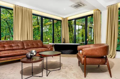 a living room with a couch and a table and chairs at Hotel Ub Aqua Park in Ub