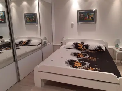 a white bedroom with a bed and mirrors at Djakuzi Viktorija in Belgrade