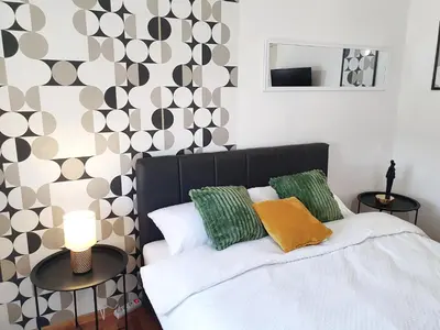 a bedroom with a bed with green and white pillows at Top Secret in Arandjelovac