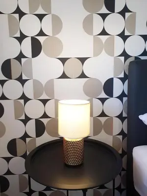 a lamp on a table in a room with a wall at Top Secret in Arandjelovac