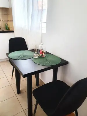 a black table with two chairs and a green placemats at Top Secret in Arandjelovac
