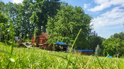 a playground in a field with grass and trees at Baberius in Babe