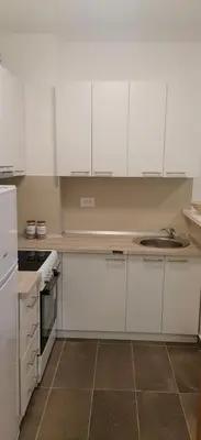a kitchen with white cabinets and a sink at MoonZe Gate in Belgrade
