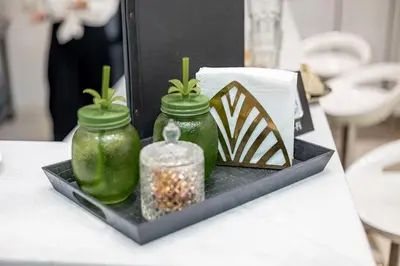 two green glass jars on a black tray on a table at ForS Konak Apartments in Belgrade