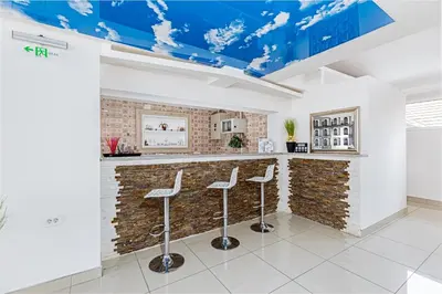 a bar with stools in front of a brick wall at ForS Konak Apartments in Belgrade
