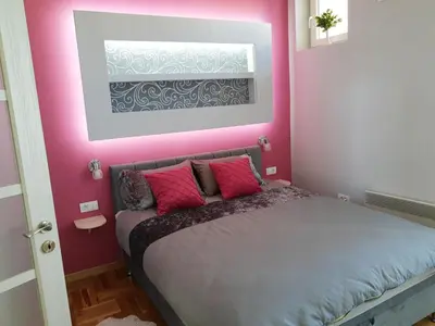 a pink bedroom with a bed with pink walls at Kalemegra in Belgrade