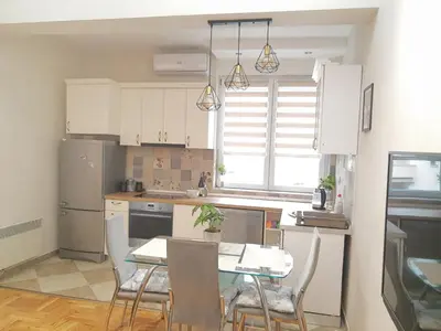 a kitchen with a table and chairs in a kitchen at Kalemegra in Belgrade