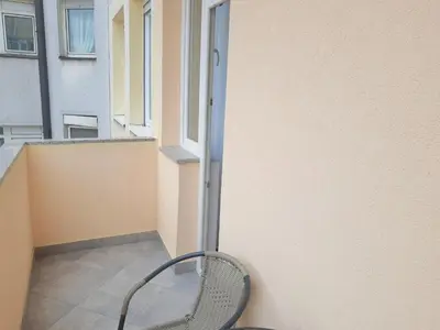 a chair sitting on a balcony next to a window at Kalemegra in Belgrade