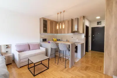 a kitchen and living room with a couch and a table at Apartment Bohemia in Belgrade