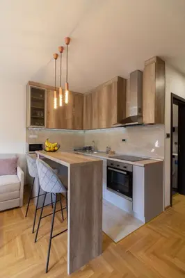 a kitchen with wooden cabinets and a counter top at Apartment Bohemia in Belgrade