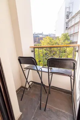 a pair of chairs sitting on a balcony at Apartment Bohemia in Belgrade