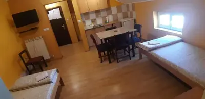 a small room with a kitchen and a table and chairs at Rosso Apartments in Belgrade