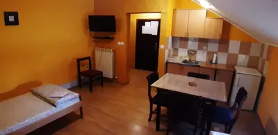 a living room with a couch and a table and a kitchen at Rosso Apartments in Belgrade
