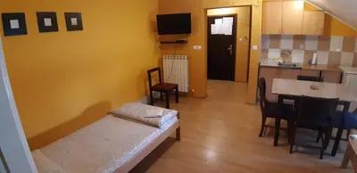 a room with a bed and a table and a kitchen at Rosso Apartments in Belgrade