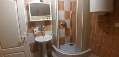 a small bathroom with a sink and a shower at Rosso Apartments in Belgrade