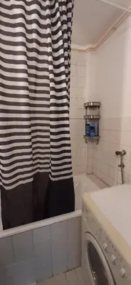 a bathroom with a shower curtain and a washing machine at Apartment Student city, Wifi 300MBs in Belgrade