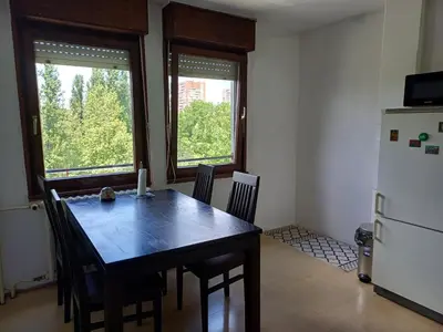 a dining room with a table and a refrigerator at Apartment Student city, Wifi 300MBs in Belgrade