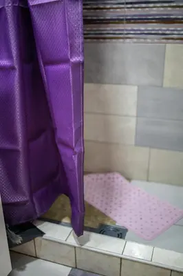 a purple shower curtain next to a pink crib at Prenoćište Inđija Hrvić in Inđija