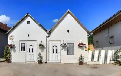 a white house with white doors and a fence at Prenoćište Inđija Hrvić in Inđija