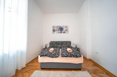 a bedroom with a bed in a room with white walls at Botanical9, Belgrade centre, 2 bedroom apartment with Netflix in Belgrade