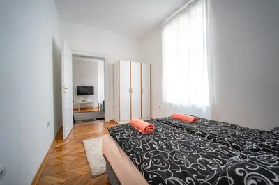 a bedroom with a bed with two orange pillows on it at Botanical9, Belgrade centre, 2 bedroom apartment with Netflix in Belgrade