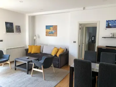 a living room with a couch and a table and chairs at Modern 1 Bed Apartment, near shopping mall Stadion in Belgrade