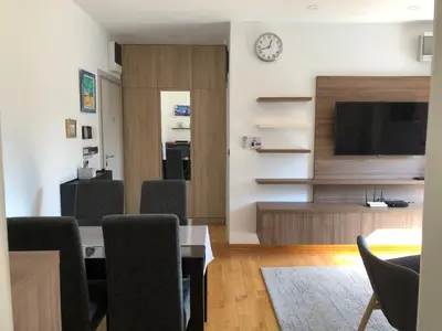 a living room with a table and chairs and a tv at Modern 1 Bed Apartment, near shopping mall Stadion in Belgrade