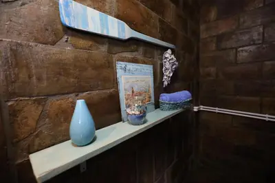 a shelf with a blue vase on a brick wall at Etno kuća Teodora in Staji°evo