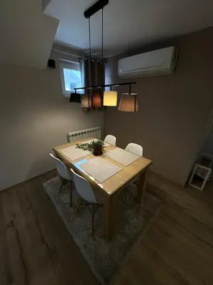 a dining room with a wooden table and chairs at Apartments LaVu in Belgrade