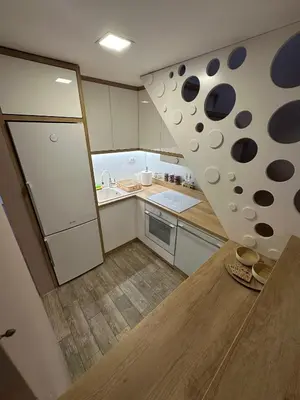 a small kitchen with white cabinets and a refrigerator at Apartments LaVu in Belgrade