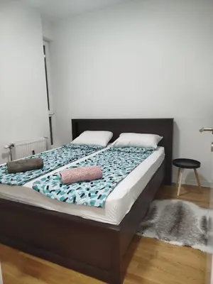 a bed with two pillows on it in a bedroom at Apartman Natasa in Karaburma