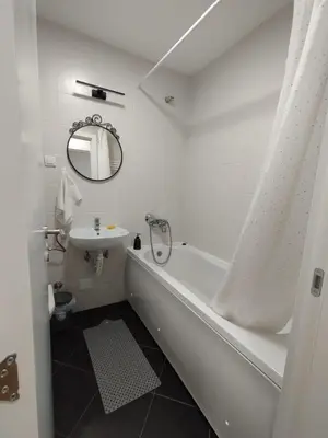 a white bathroom with a tub and a sink at Apartman Natasa in Karaburma