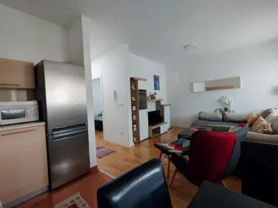 a living room with a refrigerator and a couch at Apartman Natasa in Karaburma