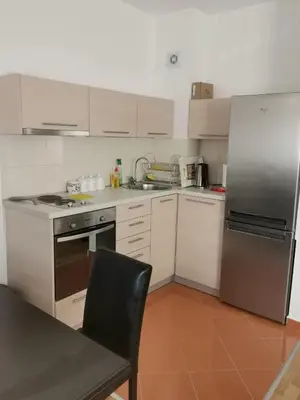 a kitchen with white cabinets and a stainless steel refrigerator at Apartman Natasa in Karaburma