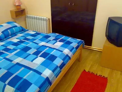 a bedroom with a blue and white bed and a television at Hostel M in Belgrade