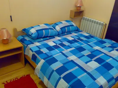 a bedroom with a blue and white bed and a table at Hostel M in Belgrade