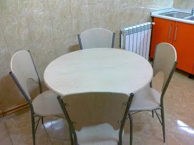 a table with four chairs and a sink in a kitchen at Hostel M in Belgrade
