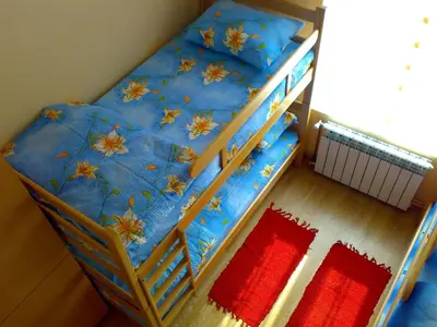 a bunk bed with a blue bedspread with flowers on it at Hostel M in Belgrade