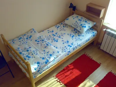 a bedroom with a bed with blue flowers on it at Hostel M in Belgrade