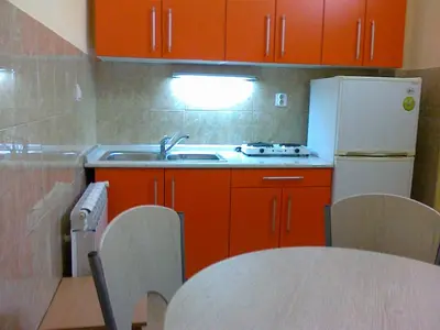 a kitchen with red cabinets and a white refrigerator at Hostel M in Belgrade