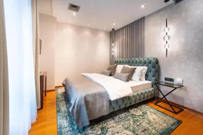 a bedroom with a bed with a green headboard at NATALI Luxury suites PARKING in Belgrade